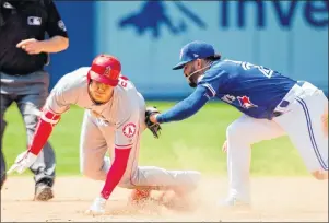  ?? CP PHOTO ?? Los Angeles Angels designated hitter Shohei Ohtani slides safely past Toronto Blue Jays second baseman Devon Travis after hitting a double during ninth inning AL action in Toronto on Thursday.