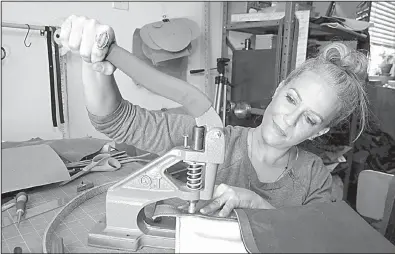  ?? TNS/Miami Herald/CHARLES TRAINOR JR. ?? Tiffany Zadi works on a purse in her studio at her home in Miami in late August.