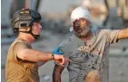  ?? HUSSEIN MALLA/ASSOCIATED PRESS ?? A Lebanese soldier directs an injured sailor while evacuating the scene of the explosion that hit the Port of Beirut.