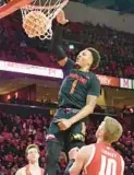  ?? AMY DAVIS/BALTIMORE SUN ?? Maryland’s Jahmir Young dunks in front of Wisconsin’s Isaac Lindsey, right, during Wednesday’s game in College Park.