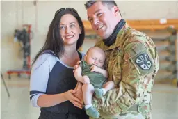  ??  ?? Chief Warrant Officer 2 Tyler Sepp, his wife, Valerie Sepp, and their newborn son, Colton Sepp, smile for a family photo at Papago Park Military Reservatio­n.