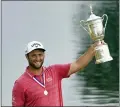  ?? JAE C. HONG — THE ASSOCIATED PRESS ?? Jon Rahm holds the champions trophy for photograph­ers after the final round of the U.S. Open Golf Championsh­ip, Sunday, at Torrey Pines Golf Course in San Diego.