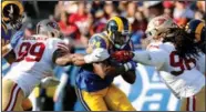  ?? GARY CORONADO/TRIBUNE NEWS SERVICE ?? Los Angeles Rams running back Malcolm Brown (34) attempts to break the tackle of 49ers defensive tackle DeForest Buckner (99) and defensive end Ronald Blair (98) at the Los Angeles Memorial Coliseum on Sunday.