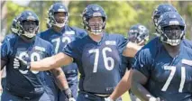  ?? BRIAN CASSELLA/CHICAGO TRIBUNE ?? Offensive lineman Teven Jenkins, center, the team’s second-round draft pick this year, has missed all nine training camp practices because of a back injury.