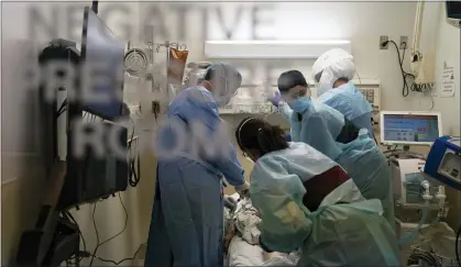  ?? ASSOCIATED PRESS FILE PHOTO ?? EMT Giselle Dorgalli, second from right, looks at a monitor while performing chest compressio­n on a patient who tested positive for coronaviru­s in the emergency room at Providence Holy Cross Medical Center in the Mission Hills section of Los Angeles, a grim scene that played out in hospitals around the country, including those in Oakland County.