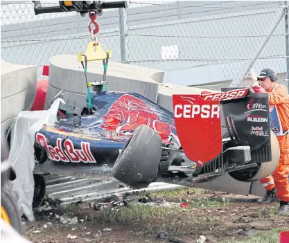  ??  ?? Course marshals remove the crashed car of Toro Rosso driver Carlos Sainz Jr.