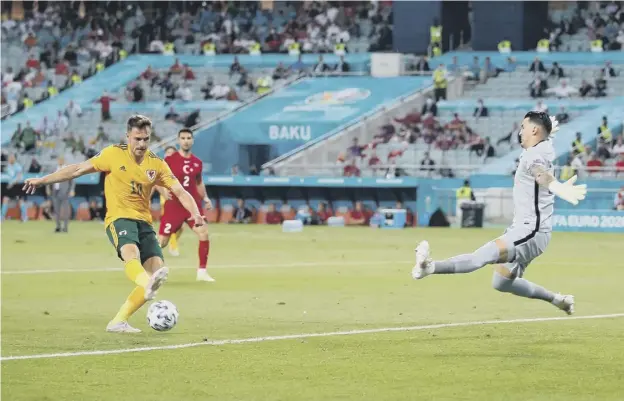  ??  ?? 0 Wales midfielder Aaron Ramsey fires the ball past goalkeeper Ugurcan Cakir to score his side’s first goal against Turkey at the Baku Olympic Stadium in Azerbaijan