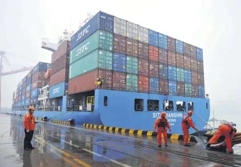  ??  ?? Workers moor a container ship at a port in Qingdao in east China’s Shandong province, Jan. 11, 2019.