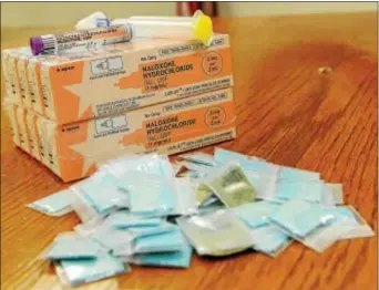  ?? DIGITAL FIRST MEDIA FILE PHOTO ?? Narcan is an opioid antagonist that can revive overdose victims if they’re found The little blue packets contain heroin which was seized by county detectives. in time.