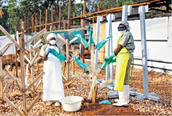  ??  ?? Health workers face a difficult task to treat Ebola patients after one medical centre in the DRC, at Butembo, was burned down