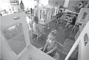  ?? MIKE DE SISTI/MILWAUKEE JOURNAL SENTINEL ?? Students in a K3-K5 class sit at their desks with protective barriers as a COVID safety measure at MacDowell Montessori School.