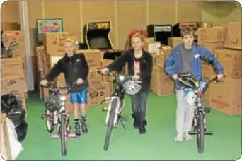  ??  ?? From left, Toys for Tots volunteers Katie Irelan, 12, of Langhorn, Nicole Middleton, 11, of Yardley and Connor Yagecic, 11, of Bensalem move bikes inside the Newtown Swim Club’s barn.