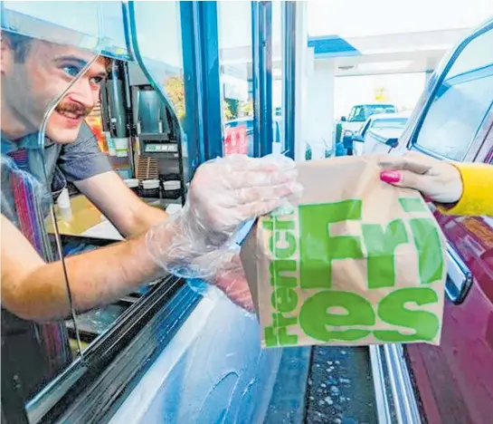  ?? Photo / Warren Buckland ?? When New Zealand’s lockdown raised to level 3 this week, it seemed the country had one thing on its mind: getting a fast-food fix. Queues were pictured outside the nation’s food outlets, including McDonald’s, where George Pohio hands an order to drive-thru customers.