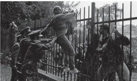  ?? FOTO: SVEN SIMON ?? Spannungen an der deutschen Botschaft in Prag: Anfangs versuchte die Polizei noch, die DDR-Bürger am Überklette­rn des Zauns zu hindern.