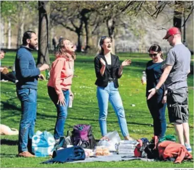  ?? ANDY RAIN / EFE ?? Cinco personas disfrutan ayer de un pícnic en St. James Park, en Londres.