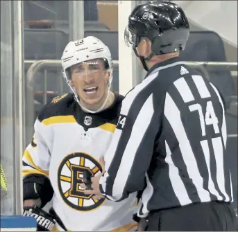  ?? BRUCE BENNETT / AP ?? Bruins forward Brad Marchand is restrained by an official during the second period of a loss to the Rangers on Friday night in New York.