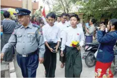  ?? — AFP ?? Myanmar students are escorted by police after a court hearing in Mandalay on Wednesday.