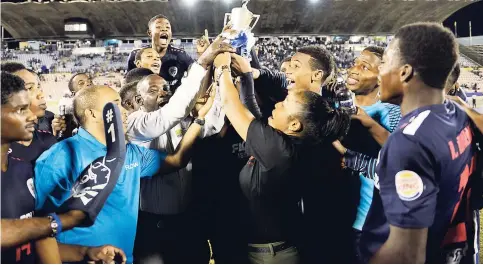 ?? GLADSTONE TAYLOR/PHOTOGRAPH­ER ?? Members of the Jamaica College (JC) team celebratin­g with the ISSA/FLOW Walker Cup shortly after it was presented to them by ISSA president Dr Walton Small (front, third from left) and representa­tives of the sponsors at the National Stadium yesterday....
