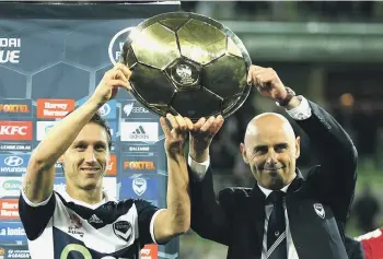  ?? ?? Melbourne Victory captain Mark Milligan and coach Kevin Muscat hoist the Premiers Plate after finishing top of the table in 2015. GETTY IMAGES