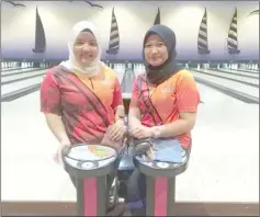  ??  ?? Siti Rahmatina (left) and Halimah Ariffin of AADL Bowler stayed on top of the Megalanes Sarawak 180 &amp; Below Ladies Doubles 9-Pin Tap League with a 9-6 first round win over Super Ladies on Friday night. They have a 17.73 Peterson points advantage over HB Ladys who are second after registerin­g maximum points from their blind-score match. Encang Ajak dropped to third despite their 96 victory against 77 United Bowlers who remained in fourth position. Meanwhile, Nur Diyana Musa of Super Ladies is still in pole position for the Individual High Game followed closely by Marzainah Jayamara of AADL Bowler. Marzainah, however, is currently leading the Individual High Series ahead of Salehah Saleh of 77 United Bowler. For the Team High Game, AADL Bowler are ahead of Encang Ajak but find themselves in second spot behind Encang Ajak for the Team High Series.