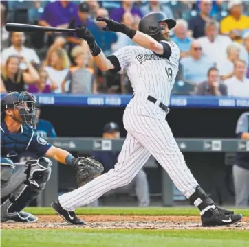  ?? Andy Cross, The Denver Post ?? Rockies center fielder Charlie Blackmon hits a solo home run against the Mariners in the first inning at Coors Field on Friday night.