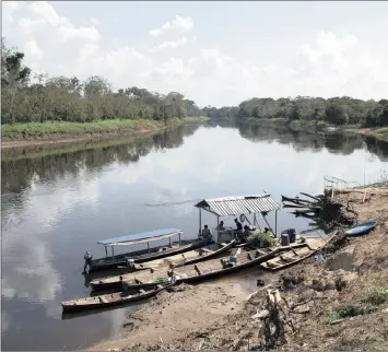  ?? PHOTO: REUTERS ?? Residents are seen on the banks of the sustainabl­e developmen­t reserve along the Amazon river in Brazil in this file photo. Chinese demand for soya, beef and transporta­tion infrastruc­ture is fuelling forest loss in Brazil.