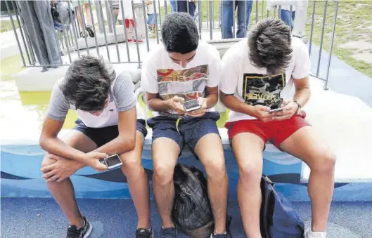 ?? MARTA G. BREA ?? Un grupo de adolescent­es jugando con sus teléfonos móviles.