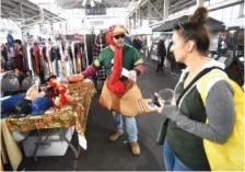  ?? ?? Right: Chattanoog­a resident Taylor Belcher talks to shoppers about the Grateful Gobbler Walk in 2021 at the Chattanoog­a Market at the First Horizon Pavilion. Chattanoog­a Market will have its final outdoor market of the season Sunday.