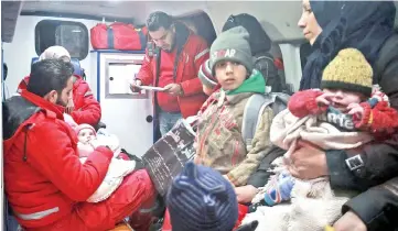  ??  ?? Syrian paramedics and civilians sit inside an ambulance on the second night of an evacuation operation led by the Syrian Red Crescent and Internatio­nal Committee of the Red Cross in Douma in the eastern Ghouta region on the outskirts of the capital...