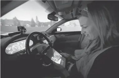  ?? MARCIO JOSE SANCHEZ /ASSOCIATED PRESS PHOTOS ?? Visiting student Stephanie Balters looks at a tablet inside a self-driving car where a simulator mimics the driving experience.