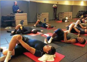  ?? MARK PODOLSKI — THE NEWS-HERALD ?? Members of the Case Western Reserve football team take part in a yoga class Sept. 29 at the Steve Belichick Weight Room.