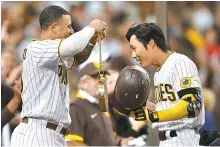  ??  ?? San Diego Padres’ Manny Machado, left, congratula­tes Kim Ha-seong at the dugout after Kim hit a solo homerun during the fifth inning of an MLB game against the Los Angeles Dodgers at PETCO Park in San Diego, Calif., Tuesday. AFP-Yonhap