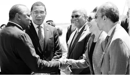  ?? BROWN/PHOTOGRAPH­ER RUDOLPH ?? Kenyan President Uhuru Kenyatta greets Foreign Affairs Minister Kamina Johnson Smith following his arrival at the Norman Manley Internatio­nal Airport yesterday. Prime Minister Andrew Holness (second left), Opposition Leader Dr Peter Phillips (third left) and Dr Horace Chang (right) look on. Kenyatta is on a three-day state visit to the island.