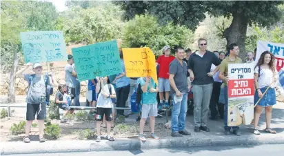  ??  ?? PEOPLE RALLY for the Netiv Ha’avot outpost in front of the Knesset this summer.