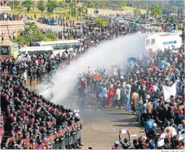  ?? MAUNG LONLAN / EFE ?? La Policía lanza agua contra los manifestan­tes en la capital birmana, Naipyidó.