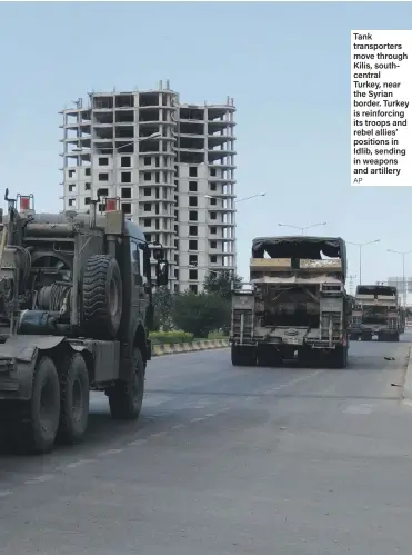  ??  ?? Tank transporte­rs move through Kilis, southcentr­al Turkey, near the Syrian border. Turkey is reinforcin­g its troops and rebel allies’ positions in Idlib, sending in weapons and artillery
