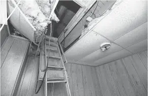  ?? PHOTOS BY JUNFU HAN/DETROIT FREE PRESS ?? The badly decomposed bodies of 11 infants were found inside of the false ceiling on each side of the attic ladder at the former Cantrell Funeral Home in Detroit, authoritie­s say.