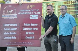  ?? JASON SIMMONDS/JOURNAL PIONEER ?? Adam Walsh, left, manager of racing at Red Shores, and drawmaster Wendell Ellis of Summerside Chrysler Dodge pose with the board displaying the post positions for the 49th running of the Governor’s Plate at Red Shores at Summerside Raceway on Saturday...