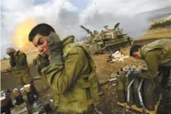  ??  ?? In this July 21, 2006 file photo, Israeli soldiers cover their ears as an artillery unit fires shells towards southern Lebanon from a position near Kiryat Shmona in northern Israel, near the border with Lebanon. —AP