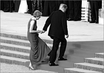  ?? WILL OLIVER/AP ?? British PM Theresa May holds President Donald Trump’s hand as they walk up to Blenheim Palace for a black tie dinner.