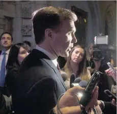  ?? ADRIAN WYLD/THE CANADIAN PRESS ?? Finance Minister Bill Morneau, speaking with reporters on Tuesday following a cabinet meeting on Parliament Hill, is faced with a deficit expected to be $1.2 billion more than anticipate­d.