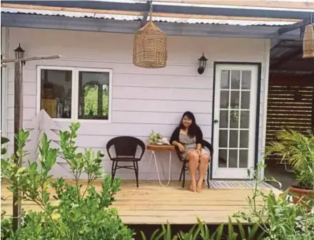  ?? PIX BY AVILA GERALDINE ?? Sheena Sonnia Yee sitting outside her tiny home, which she designed and built on a piece of land next to her family’s house in Tamparuli, Sabah.