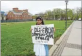  ??  ?? A TCNJ student holds up a sign outside Green Hall, where his peers held a protest next door to the president’s officer. The TCNJ Committee on Unity is demanding the college to keep open its clinic and rename Loser Hall.