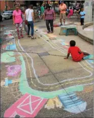  ?? MICHILEA PATTERSON — DIGITAL FIRST MEDIA ?? People test out their art skills as they fill in a sketch of a town during the sidewalk chalk festival at the Smith Family Plaza on Thursday. The activity was part of the “Almost Friday” event of the weekly outdoor farmers market in Pottstown.