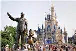  ?? Libo Tang/Dreamstime/TNS ?? ■ A statue of Walt Disney with Mickey Mouse stands at the entrance to Cinderella’s Castle at Disney World in Orlando, Fla.