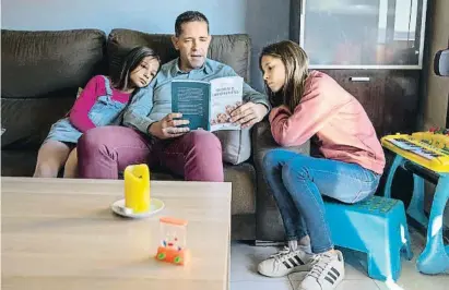  ?? Mané Espinosa ?? Un pare llegint a les seves filles de diferent edat
