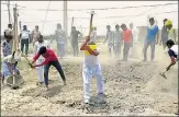  ?? HT PHOTO ?? Minister Rajbhar (in yellow turban, centre) at work rebuilding the road leading to his house in Fatehpur Khonda village