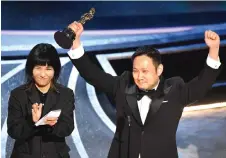  ?? — AFP photo ?? Hamaguchi (right )accepts the award for Best Internatio­nal Feature Film for ‘Drive My Car’ onstage during the 94th Oscars at the Dolby Theatre in Hollywood, California.