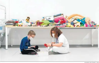  ?? GUSTAVO VALIENTE / EFE ?? Una trabajador­a sanitaria juega con un niño procedente de Ucrania en el hospital Isabel Zendal de Madrid.