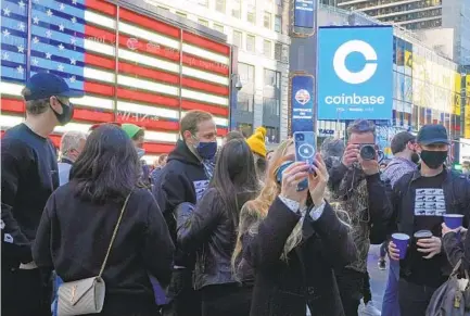  ?? RICHARD DREW AP ?? Coinbase employees gather outside the Nasdaq MarketSite in New York’s Times Square during the company’s IPO on Wednesday.